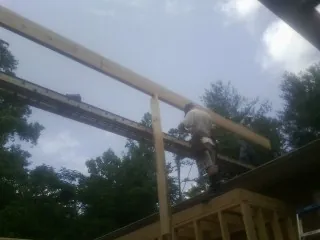Carpenter setting a ridge beam over a new addition frame — Ice Dam Removal by Roofing Brothers in Sunset Beach