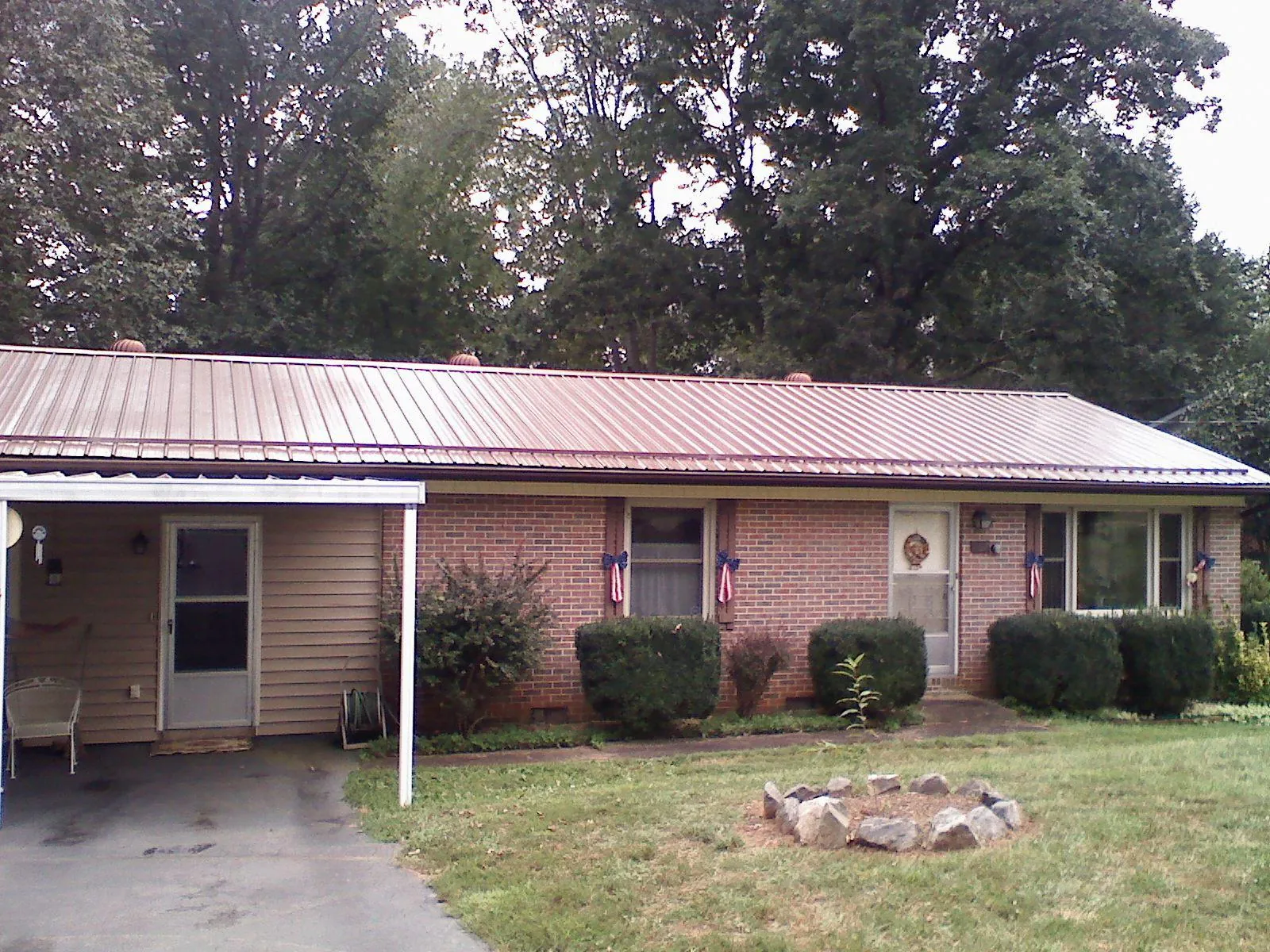 Bronze metal roof and carport on a brick ranch home — Roof Repair work by our crew in Sunset Beach